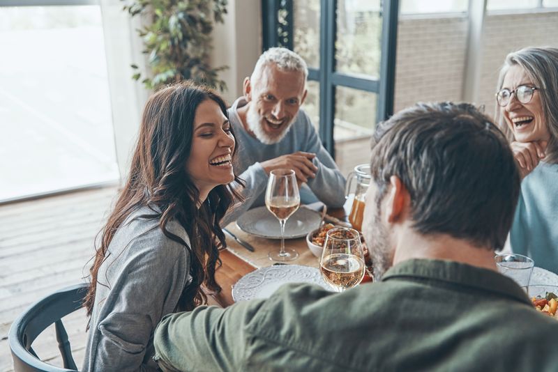 Happy family communicating and smiling while having dinner together